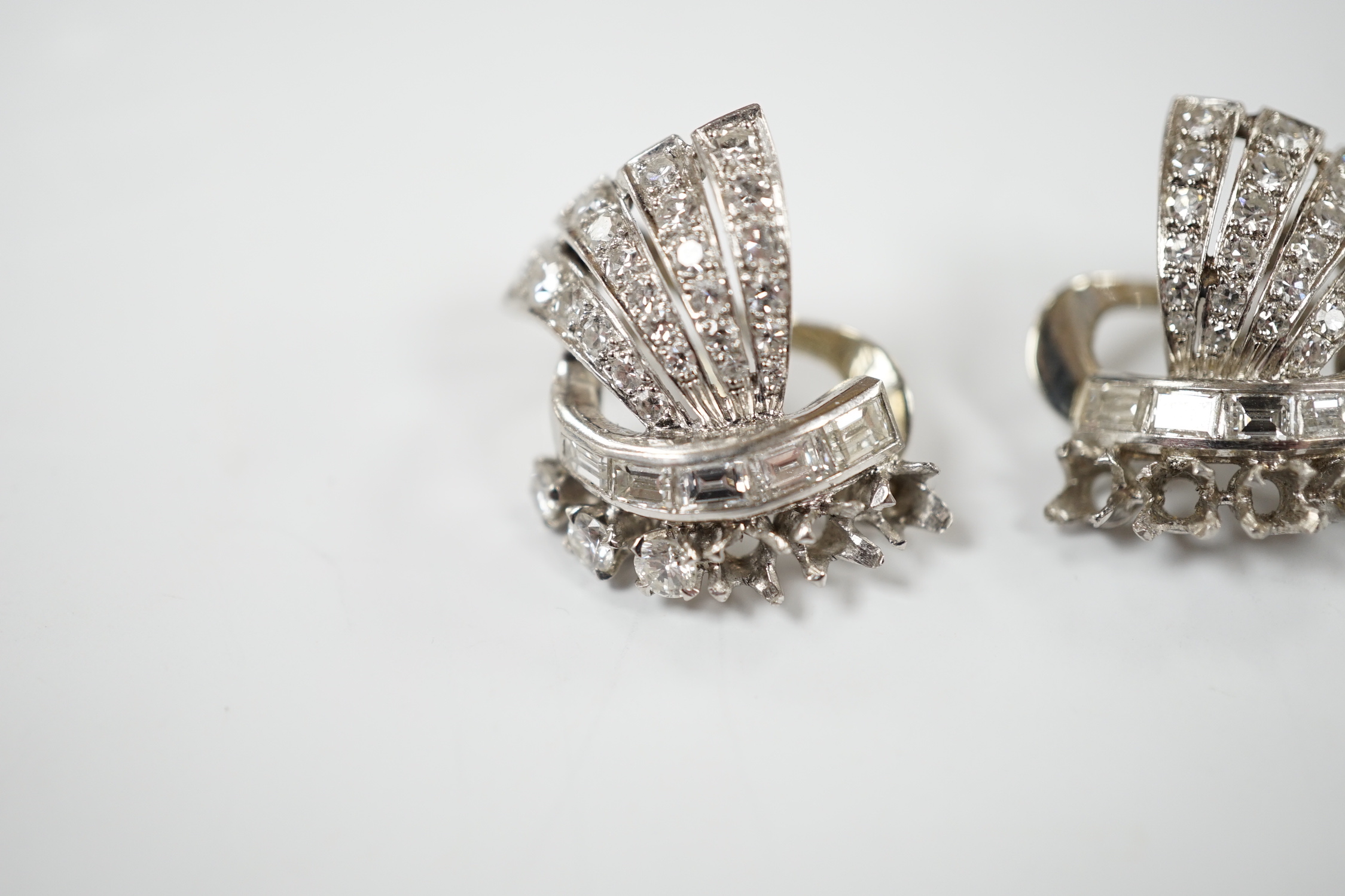 A pair of white metal, round and baguette cut diamond cluster set fan shaped earrings, 20mm, gross weight 10.7 grams (three stones missing from each).